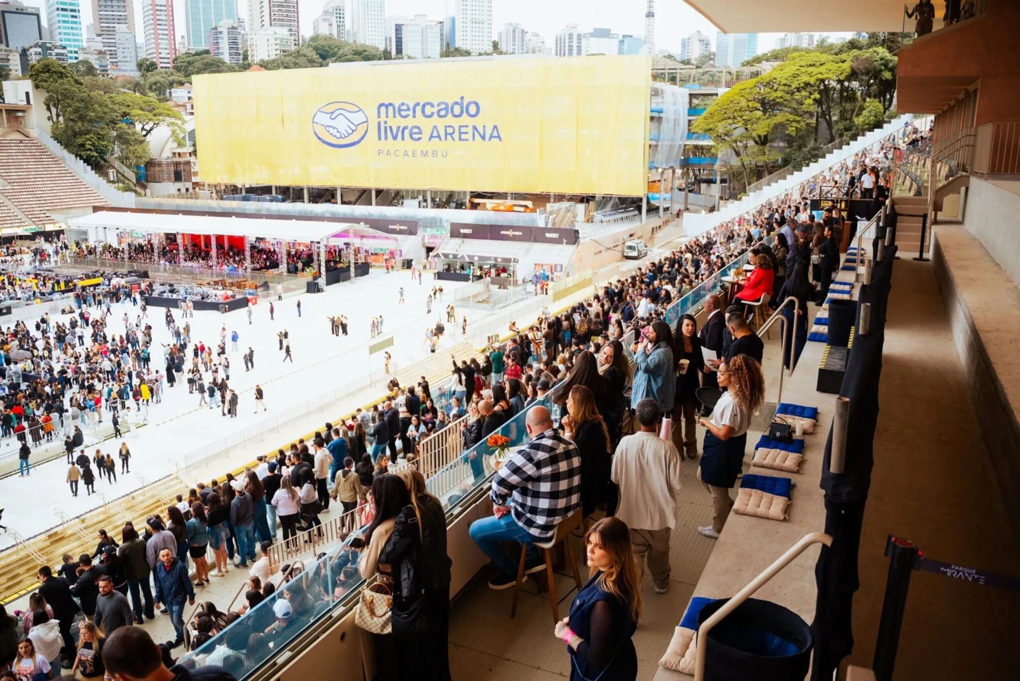 Tribuna do Salão Nobre com convidados diante do campo, de dia
