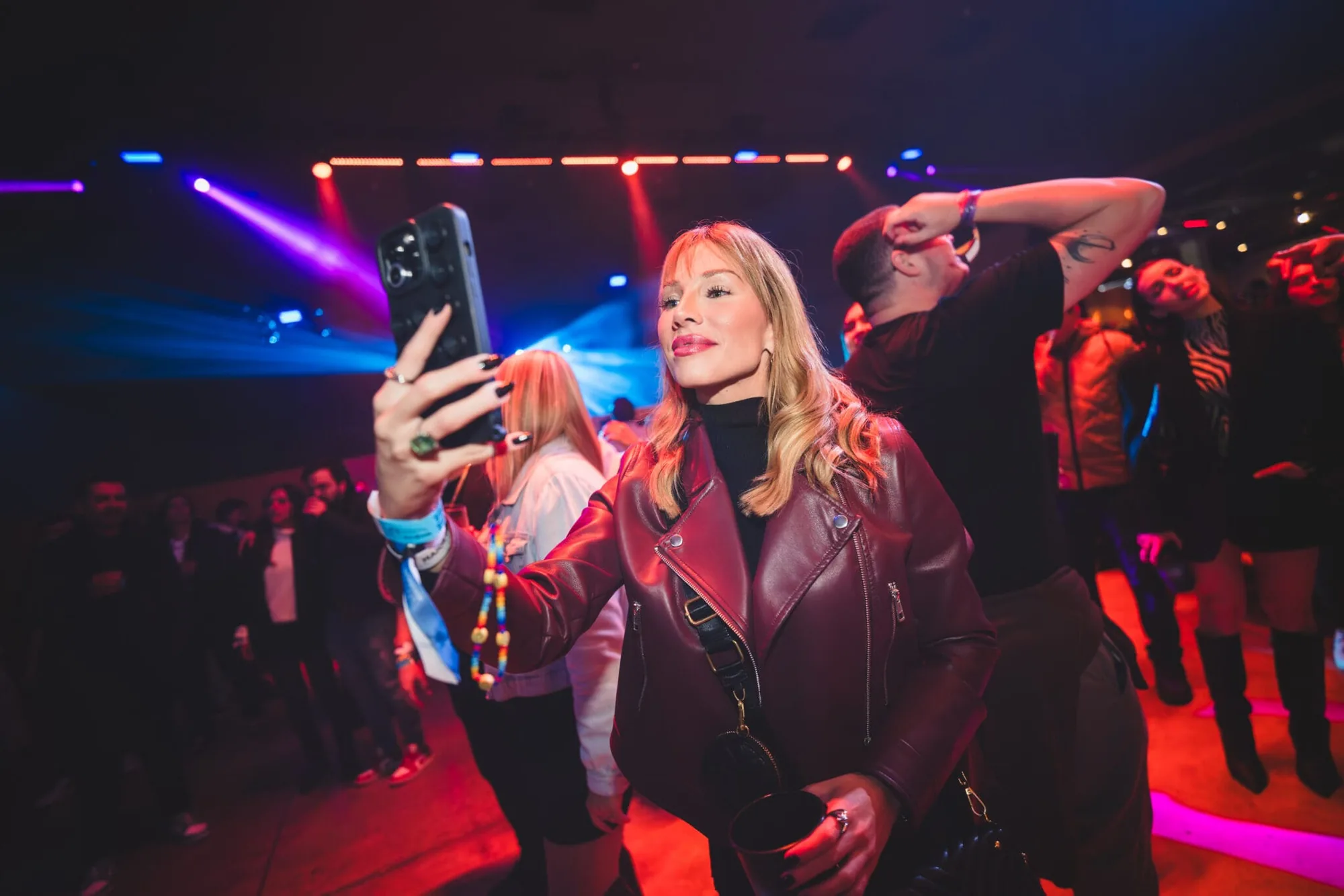 Convidadas fazem selfie na pista com luzes vermelhas